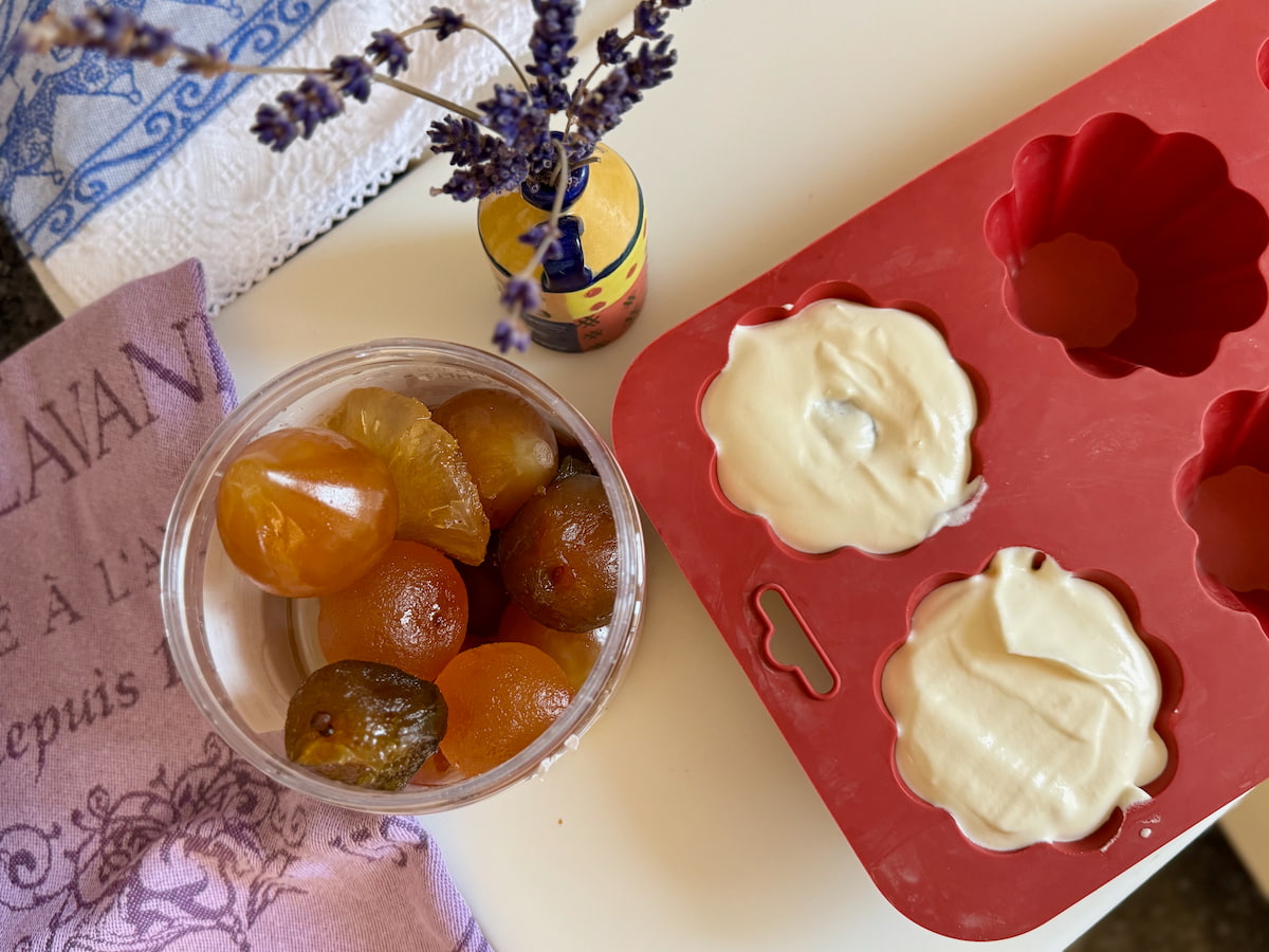 Plombieres-ice-cream-lavender-apricot-sauce a tub of whole candied fruits next to silicone brioche moulds with ice cream made with whipping cream