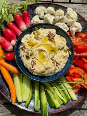 bowl of creamy chickpea spread with extra garlic the French way, served with raw vegetables